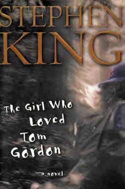 Cover of the novel The Girl Who Loved Tom Gordon by Stephen King. The design is a misty forest scene with a young girl wearing a baseball cap and backpack, walking alone. The title appears in white handwritten-style text. Stephen King's name is at the top in large gold lettering.