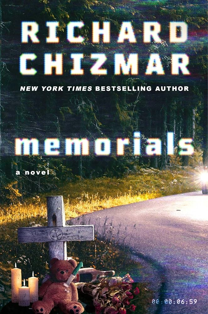 Book cover of Memorials by Richard Chizmar. The background shows a dark, wooded roadside, with a narrow road curving. In the foreground is a small roadside memorial with a wooden cross, a teddy bear, flowers, and lit candles. The title “memorials” appears in lowercase across the center, and Richard Chizmar is shown all capital letters at the top.