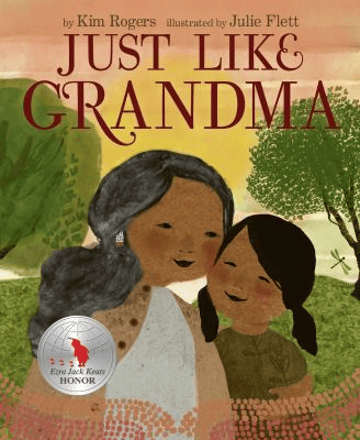 Cover of Just Like Grandma by Kim Rogers and illustrated by Julie Flett. Features a grandmother and her grandduaghter with two trees and a dragonfly behind them. The book has an Ezra Jack Keats Honor.